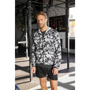 A men's sports jacket in a black and white abstract pattern, featuring a zip front and a hood, suitable for athletic wear.