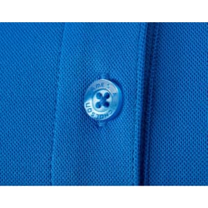 A close-up of a blue polo shirt featuring textured fabric and a button with a logo.