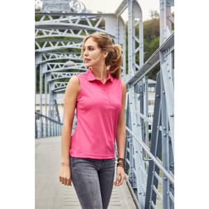 A sleeveless pink polo shirt on a model standing on a bridge, featuring a collar and a logo.