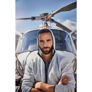 A men's knitted fleece hoodie in grey, worn by a man standing in front of a helicopter, featuring a hood and branding.