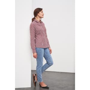 A checked blouse in red and white, paired with blue jeans. The model stands against a plain background.