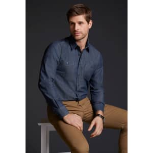 A men's button-up denim shirt in dark blue, featuring two chest pockets, worn with tan trousers.