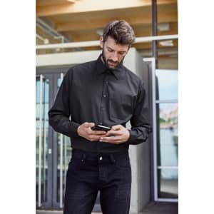 A black long-sleeved business shirt with a button-up front and a chest pocket, worn with dark jeans.
