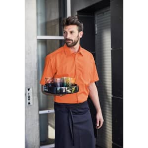 An orange short-sleeved button-up shirt worn by a man holding a tray, standing by a building entrance.
