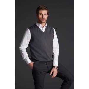 A grey men's v-neck vest is worn over a white shirt, paired with dark trousers. The model is standing with one hand in his pocket.