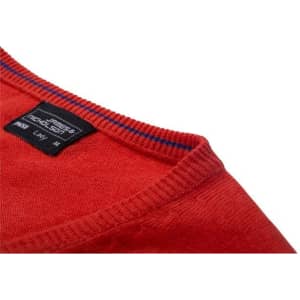 A red knitted jumper with a V-neck design and a label on the inside neckline.