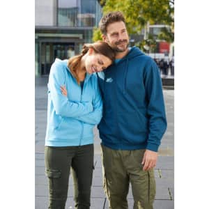 A blue and light blue zip hoodie on a woman and a man outdoors, featuring a logo on the hoodie.