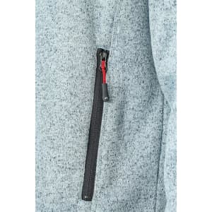 A zipped pocket on a light grey men's knitted fleece jacket, featuring a contrasting black zip and red pull.