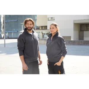 A grey workwear half zip sweat, worn by a male and female model in an urban setting.