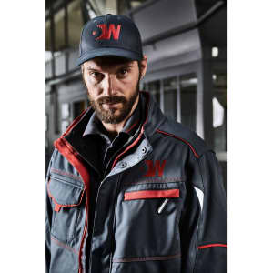 A workwear jacket in navy with red accents worn by a man. The jacket features pockets and has a logo.