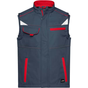 A workwear softshell vest in navy blue with red accents and reflective detailing. Includes multiple pockets and a logo.