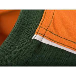 A close-up of a men's workwear t-shirt featuring orange and green fabric with contrasting stitching.