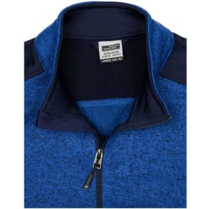 A blue knitted workwear fleece jacket featuring a high collar and a zip. It has contrasting navy panels and a logo.