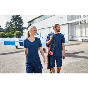A navy blue men's workwear T-shirt, featured with a logo, alongside a model in a similar colour and setting.