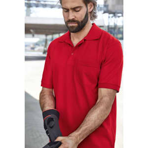 A red men's polo shirt with a pocket, worn by a man adjusting a sleeve. The shirt features a subtle branding logo.