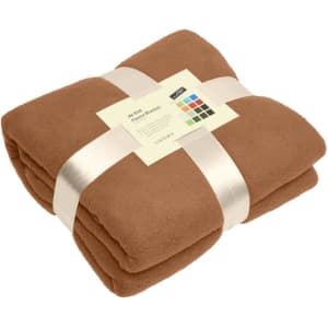 A folded brown fleece blanket tied with a ribbon, featuring a label and a logo.