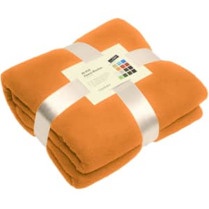 An orange fleece blanket neatly folded and tied with a ribbon, featuring a label and a logo.