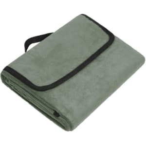 A folded green picnic blanket with a black trim and a carrying strap.