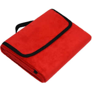 A red picnic blanket folded with a black trim and strap for easy carrying.