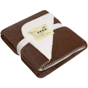 A brown and cream fleece blanket, neatly folded and wrapped with a band, featuring a textured edge and a logo.