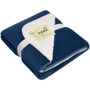 A navy blue blanket featuring a soft, fluffy white reverse side, neatly folded and secured with a band.