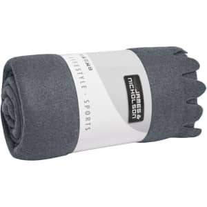 A rolled grey fleece blanket wrapped in a label featuring a logo. Soft and cosy material evident.