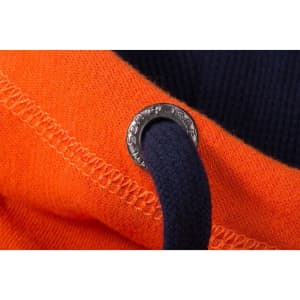 A close-up of an orange zip-hoodie featuring a navy drawstring and a branded metal eyelet.