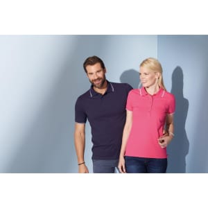 A navy blue polo shirt and a pink polo shirt feature a contrasting collar and are worn by a man and a woman.