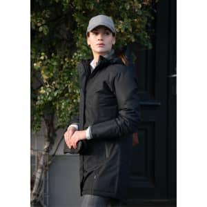 A black puffer jacket with a hood, worn by a woman outdoors, complemented by a grey cap.