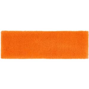An orange terry headband featuring a soft, textured surface and a logo on one side.