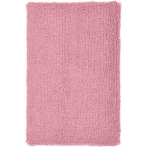 A fluffy, pink, rectangular wristband with a soft texture. It features a logo in one corner.