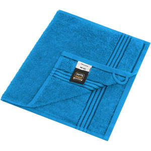 A blue guest towel with a textured surface and striped detail, featuring a brand label.