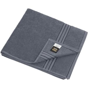 A grey bath towel with a textured design and a folded edge. It features a small logo tag on one corner.