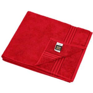 A red sauna sheet with a textured surface and folded corner revealing a label, showcasing a solid colour design.