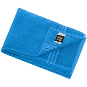 A blue bath sheet with a folded corner, featuring a brand logo on the edge.