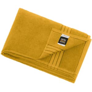A yellow bath sheet, folded neatly with a corner flap and a sewn-in label.