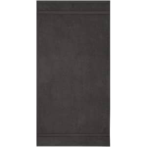 A hand towel in a dark grey colour with a simple, textured design and a branding logo.