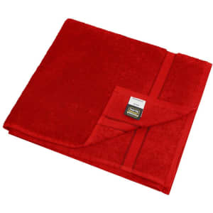 A red bath towel folded neatly, featuring a small pocket and a branding label.