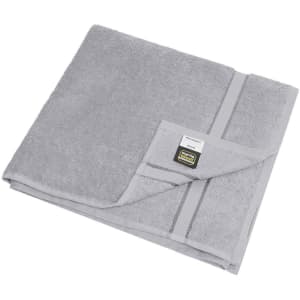 A grey bath towel with a folded corner and a logo tag. Soft, plush texture visible.