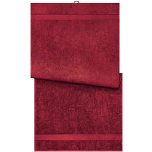 A red bath towel, featuring a textured design and decorative stripes, displayed folded. It has a subtle logo.
