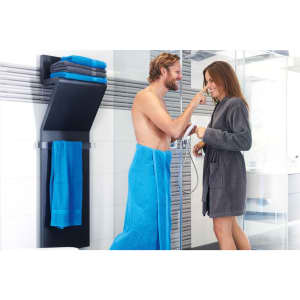 A couple in a bathroom, one wrapped in a vibrant turquoise bath sheet, the other in a grey robe, interacting playfully.