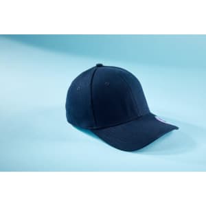 A navy blue 6 panel elastic fit baseball cap with a logo on the side, resting on a light blue background.