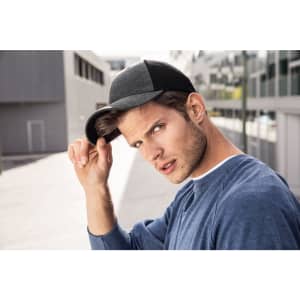 A black and grey 6 panel elastic fit mesh cap worn by a man outdoors, adjusting the brim with one hand.