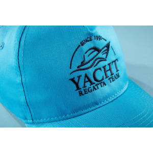 A light blue 5 panel cap made of organic cotton featuring a logo embroidered on the front.