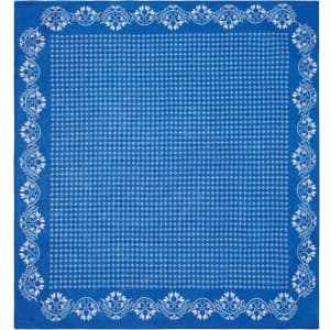 A blue bandana featuring a white floral border and a polka dot pattern in the centre. It has a logo.