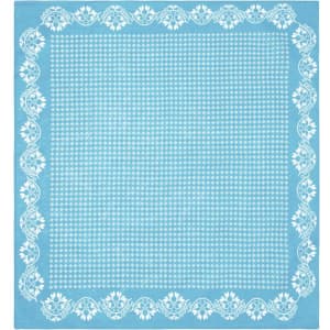 A light blue bandana featuring a white floral pattern along the edges and a polka dot centre.