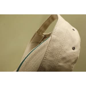 A beige military-style cap featuring a logo, with a contrasting coloured inner lining.