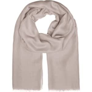 A light beige scarf with a soft texture and fringed edges, featuring a logo. Ideal for adding a stylish touch.