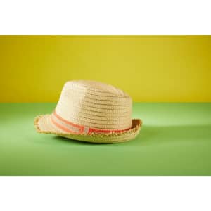 A straw summer hat with a frayed brim and an orange band, set against a green and yellow background.