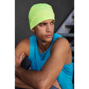 A bright yellow running beanie worn by a person in a blue tank top, sitting with arms crossed.
